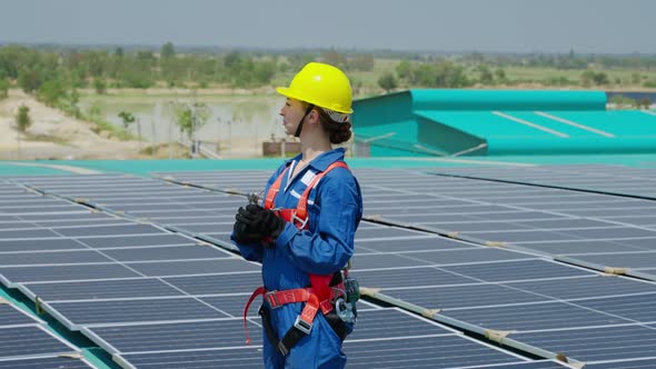 female worker attaching solar panels to the roof of the factory