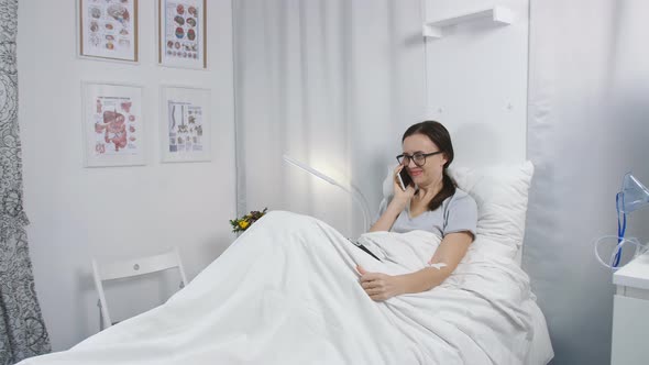 The Woman in the Hospital Lying in Bed and Talking on the Phone with Relatives