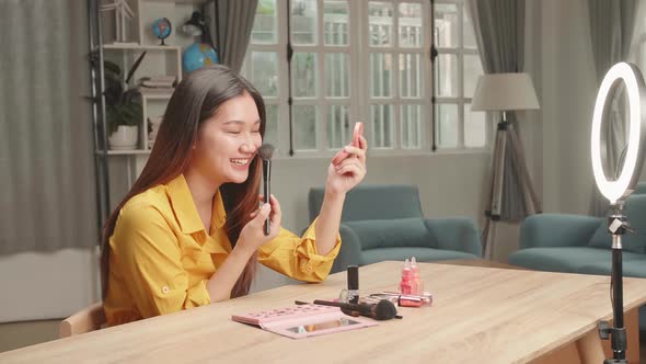 Asia Beauty Blogger Woman Make-Up With Cosmetic Powder Brush At Home Studio alt