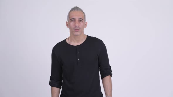 Handsome Persian Man Looking Shocked Against White Background alt