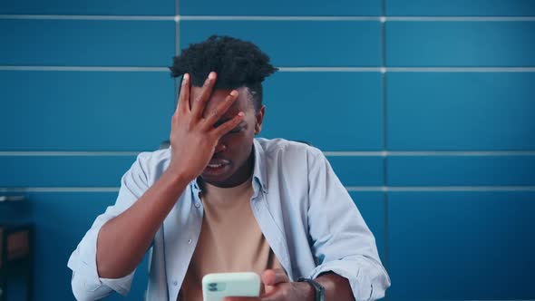 Young Annoyed African American Man Get Angry After Seeing Message on Phone alt