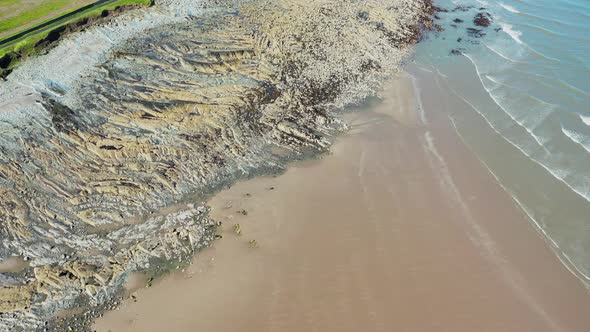 Aerial top-down view over a natural rock formation on the Irish beach alt