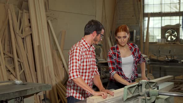 Two Young Carpenters Doing Woodwork at Furniture Manufacturing alt