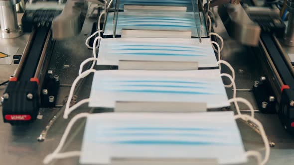 Medical Masks Moving Along a Conveyor at a Face Mask Production Factory alt
