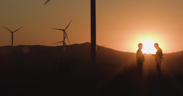 Engineers Look at the Information in the Tablet at Sunset. Silhouette Shooting. The Concept of alt
