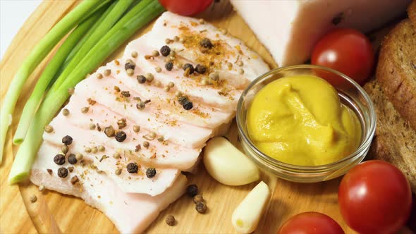 Chopped Lard on a Board with Spices Pepper Mustard Cherry Tomatoes Garlic Green Onions Black Bread alt