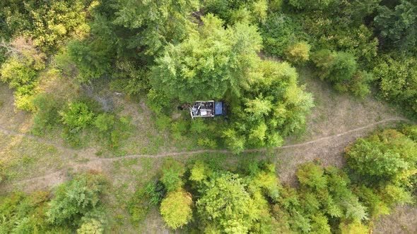 Blue, abandoned pick up truck filled with garbage in the woods of British Columbia at sunset. High a alt