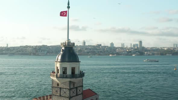 Maiden's Tower Establishing Shot in the Middle of the Bosphorus Water in Istanbul with Turkey Flag alt