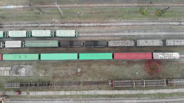 Cargo trains and freight wagons with goods on railway station tracks alt