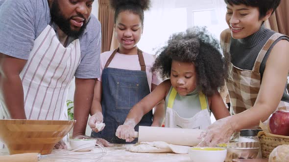 Two Kids and family preparing flour to make bread in kitchen at home.