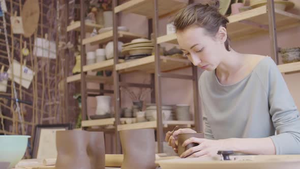 Blond-haired Woman Sculpting in Ceramic Studio alt