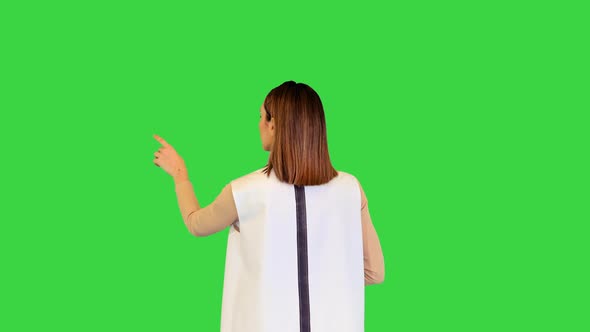 Android Girl Stands Operating Virtual Monitors on a Green Screen Chroma Key