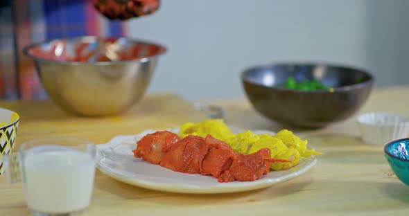 Cook Puts Slices of Raw Pickled Meat in Spices on Skewers and Puts on a Plate alt