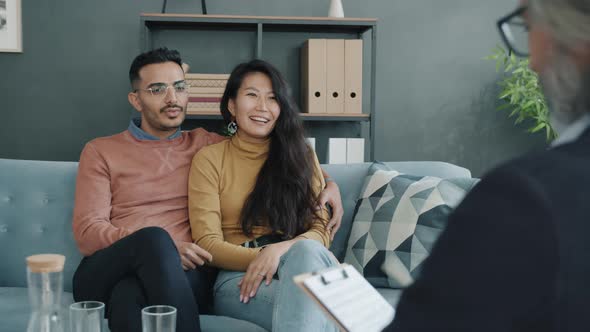 Biracial Couple Sharing Marital Problems with Therapist During Family Consultation in Office alt