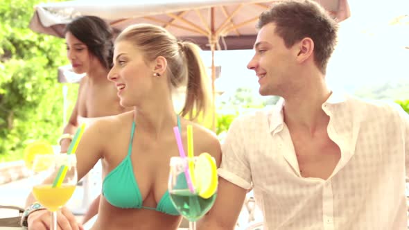 Two Young Couples of Friends at Water Park in Summer Day are Drinking Cocktails at Bar