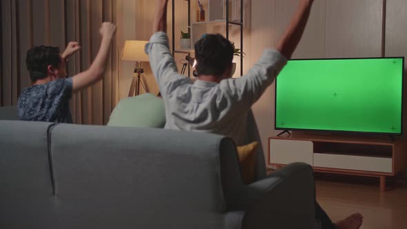 Happy Time Of Young Friends Cheering And Watching Green Screen Tv And Celebrating Victory At Home alt