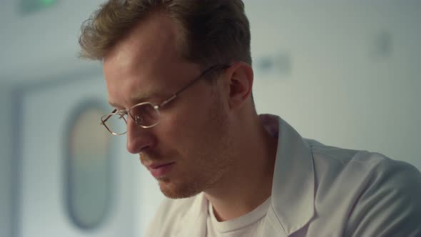 Man Doctor Working Remotely Using Computer in Hospital Closeup alt