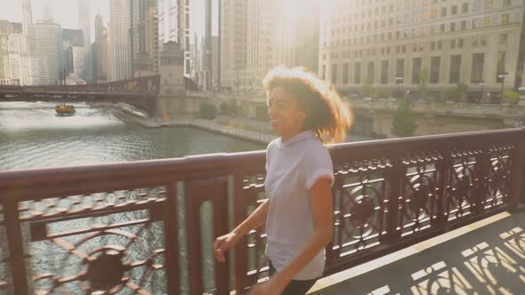 African American woman skips over one of the bridges crossing the Chicago River alt