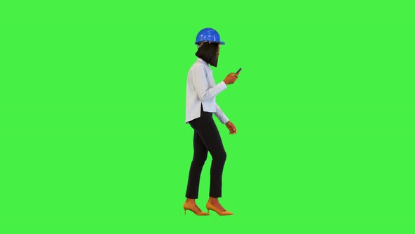 Young African Woman Walk Read or Type Message on Smartphone Wearing Protective Construction Helmet