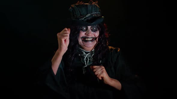 Frightening Senior Woman with Halloween Witch Makeup Listening Music Smiling Dancing to Disco Music alt