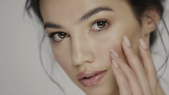 Cute Brunette Treating Her Face and Smiling with Perfect Smile alt