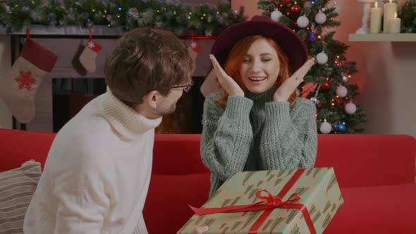 Man surprises his girlfriend with a Christmas present. alt