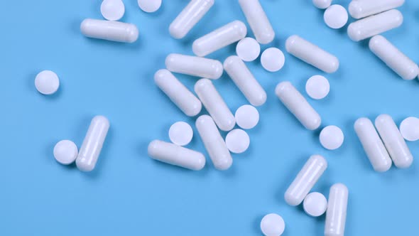 White Pills and Capsules Medicines on a Blue Background the Concept of Pharmacology Medicine or alt