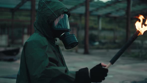Soldier Man with Gas Mask in a Destroyed Building By War with Torch alt