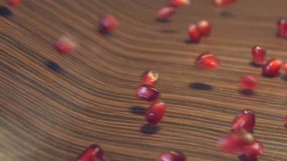 Pomegranate Grains on Brown Wooden Background.
