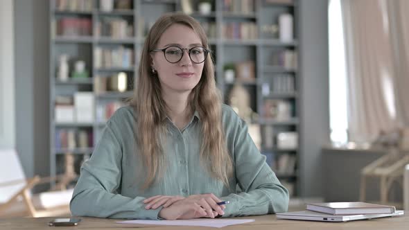 Ambitious Woman Looking at Camera While Sitting in Office alt