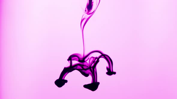 Creative Abstract Shot of Magenta Ink Dropped in Water on Pink Background alt