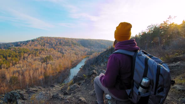 Woman Sits on Mountain Slope Edge alt