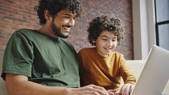Elder and Younger Siblings Play Game Together in Laptop alt