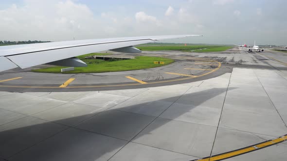 The Runway Under Wing of Aircraft. Airplane Moving on the Runway in Terminal of Departure in the