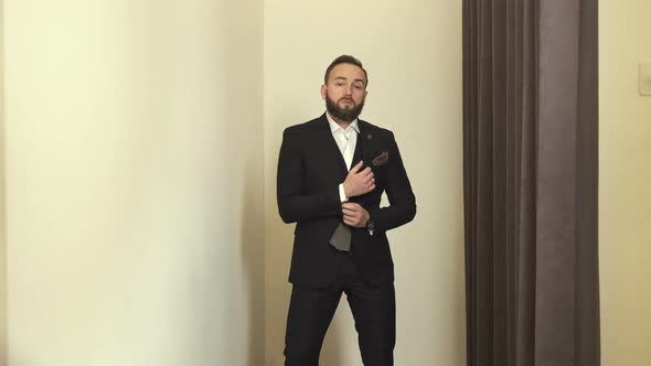 Stylish Young Man In Fitting Room Trying On New Suit. alt