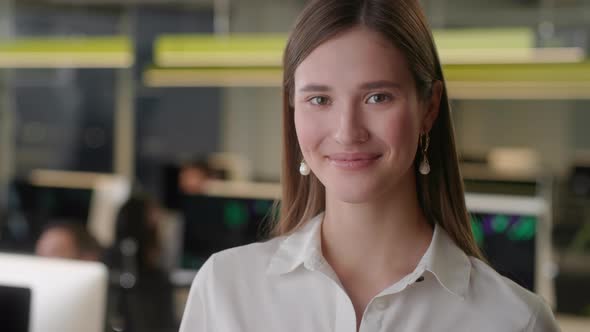 Portrait of Beautiful Young Woman Wearing White Shirt Looking Up to the Camera and Smiling alt