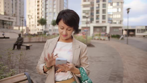 Business Woman Using Phone on the Street and Smiling Pedestrianized Street