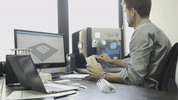 Man using desktop 3-D printer in office