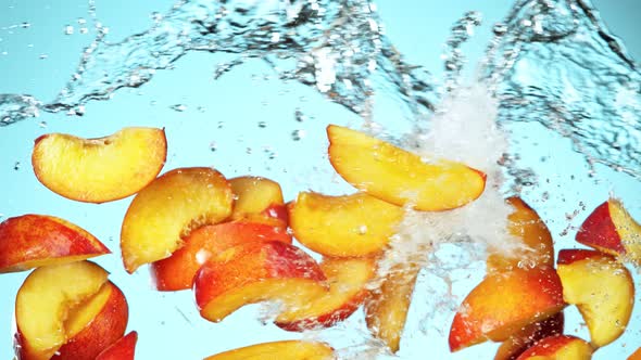 Super Slow Motion Shot of Flying Fresh Peach Slices and Water Side Splash on Light Blue at 1000Fps. alt