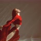 Attractive red-haired young woman swims beautifully underwater in a red dress. slow motion