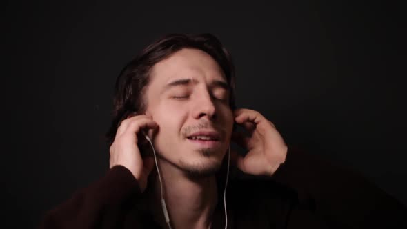 A Man Listens to Music with Headphones Man Sings Low Key Gray