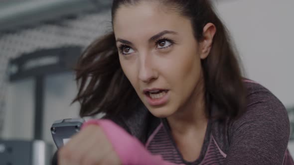 Handheld view of tired woman exercising in the gym.  Shot with RED helium camera in 8K alt