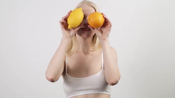 Attractive Woman Dancing with Fresh Orange and Lemon Happy To Spend Time at Home alt