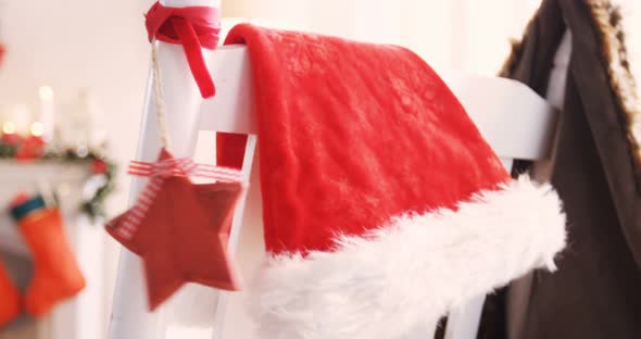 Santa hat and christmas decoration hanging on chair 4k alt