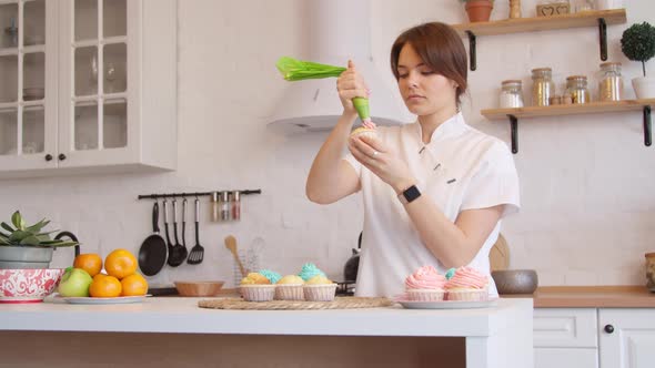 Woman Icing Cupcakes in Kitchen