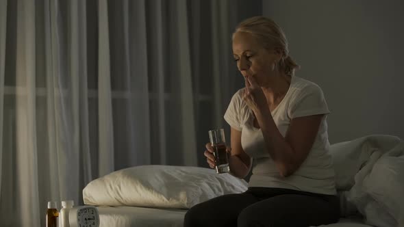 Mature Woman Suffering from Depression Taking Antidepressants to Calm Down alt