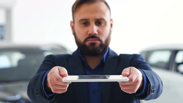 Image for Graphic Implements. Businessman Holds a Tablet with HUD Futuristic Elements