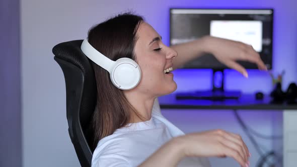 Young Caucasian Woman Relaxing on Comfortable Armchair with Eyes Closed Using Wireless Earphones alt