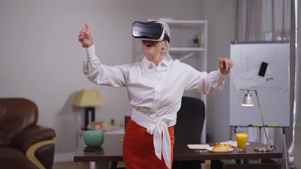 Mature Woman Enjoying Augmented Reality in VR Headset on Break in Office alt