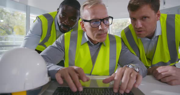 Confident Team of Architect Working Together in Office Looking at Computer Screen alt